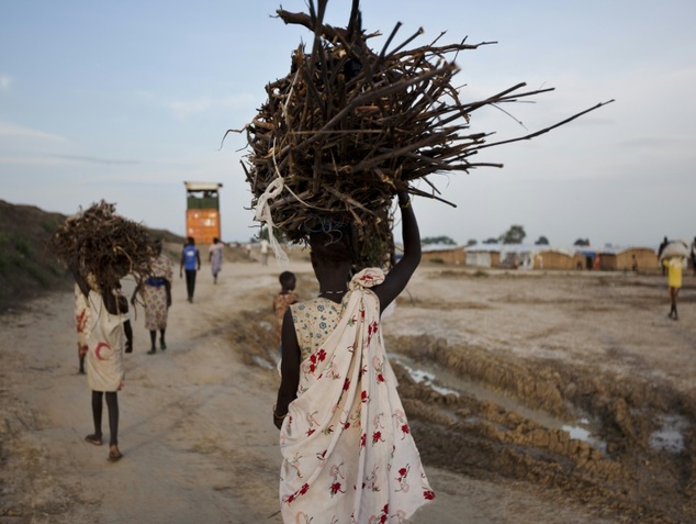 A young woman carries firewood after returning to the United Nations base outside Bentiu
